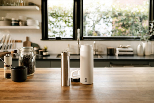 MiiR Stailess Cold Brew filter next to MiiR white Wide Mouth Bottle on kitchen counter top