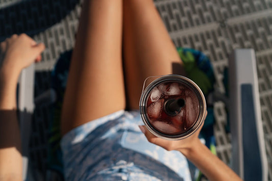 Sunny overhead shot of a person in the sun holding MiiR Straw Tumbler containing iced drink