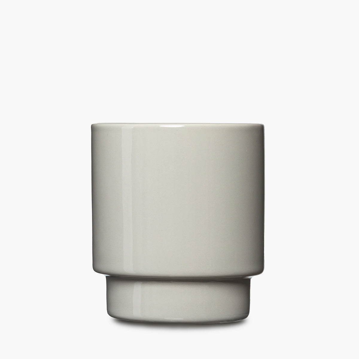 A minimalist ceramic cup with a matte finish, featuring a cylindrical body and a flared base, in a light gray color.