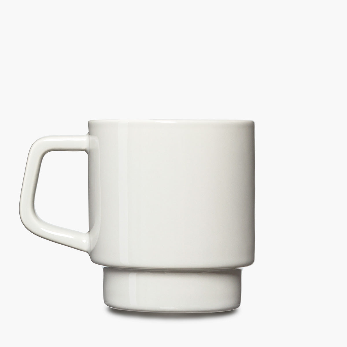 A minimalist white ceramic mug with a thick, integrated handle and a matching circular base.