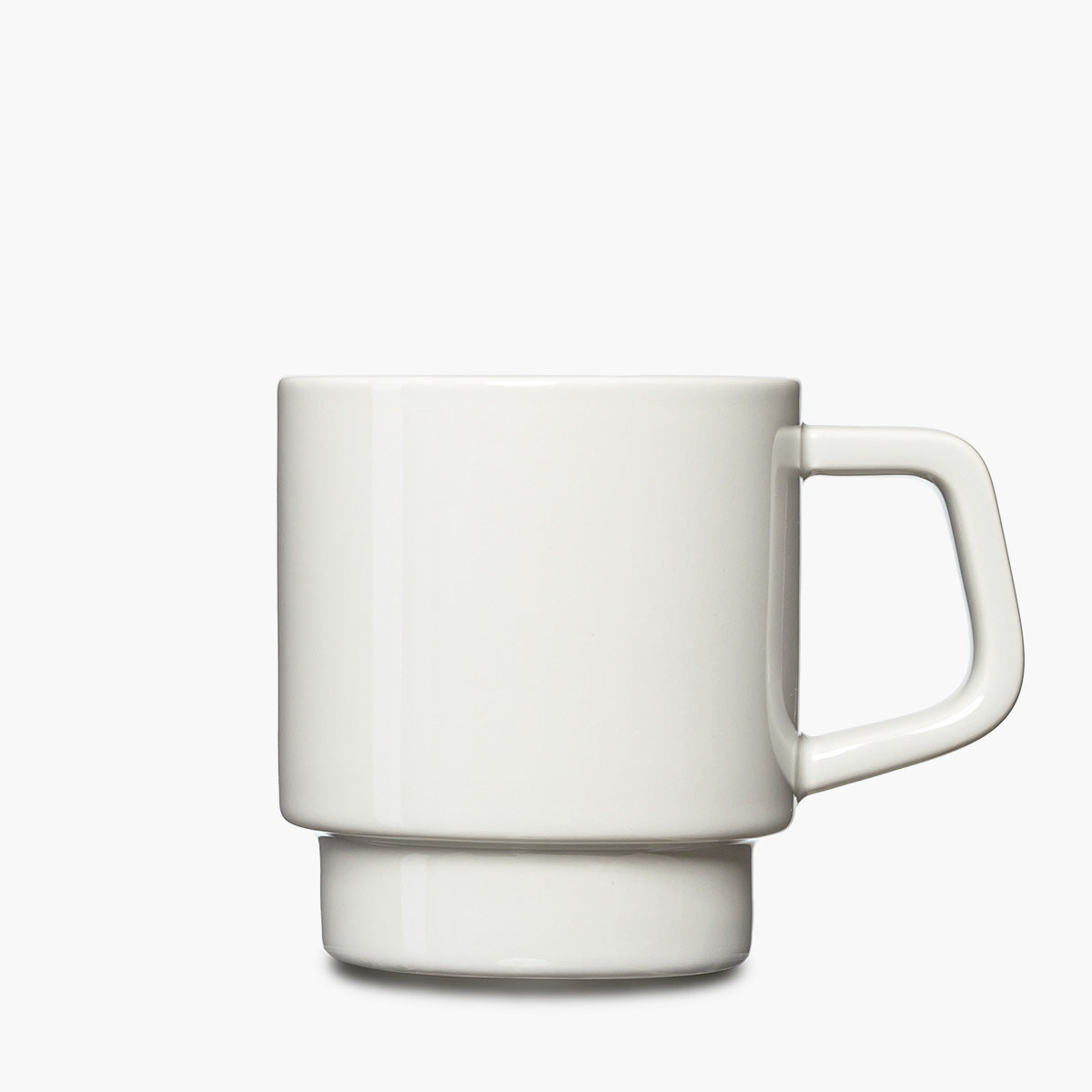 A minimalist white ceramic mug with a thick, geometric handle and a matching ridged base.