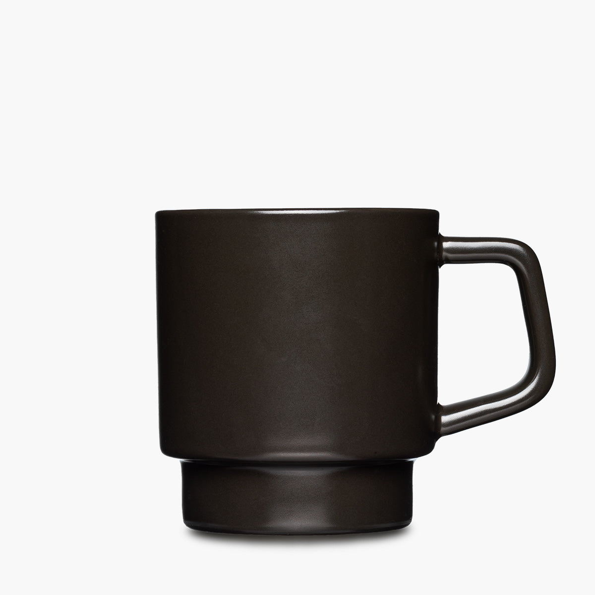 A matte black ceramic mug with a thick, integrated handle and a matching base.