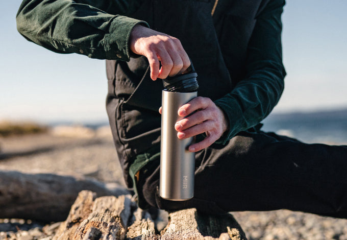 A man opening the MiiR Climate+ bottle